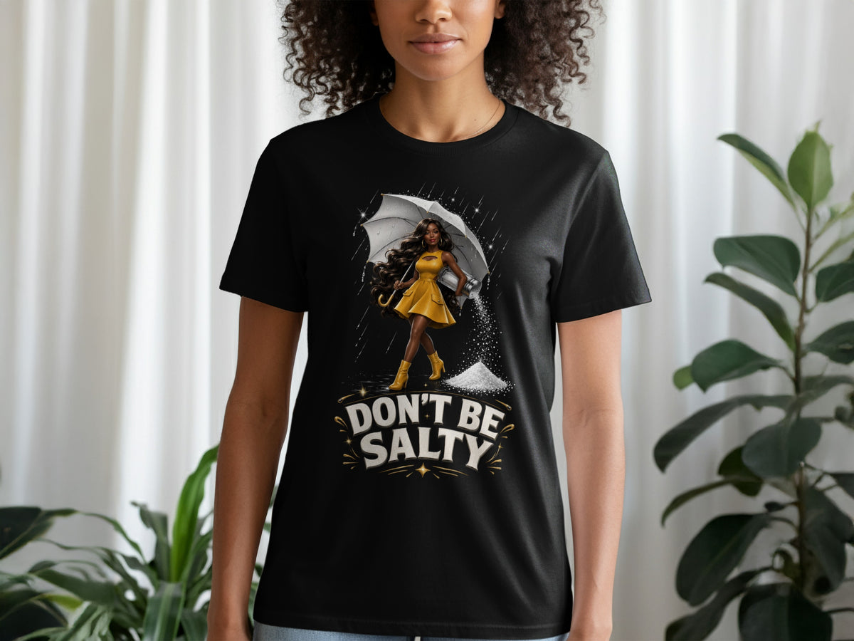 Black t-shirt with "DON'T BE SALTY" text and illustration of a woman with an umbrella and salt shaker.