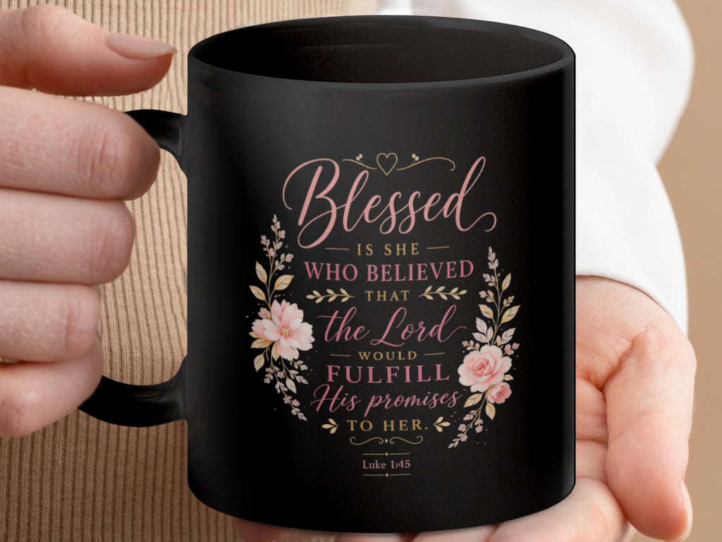 Black mug with pink floral design and text "Blessed is she who believed that the Lord would fulfill His promises to her. Luke 1:45"