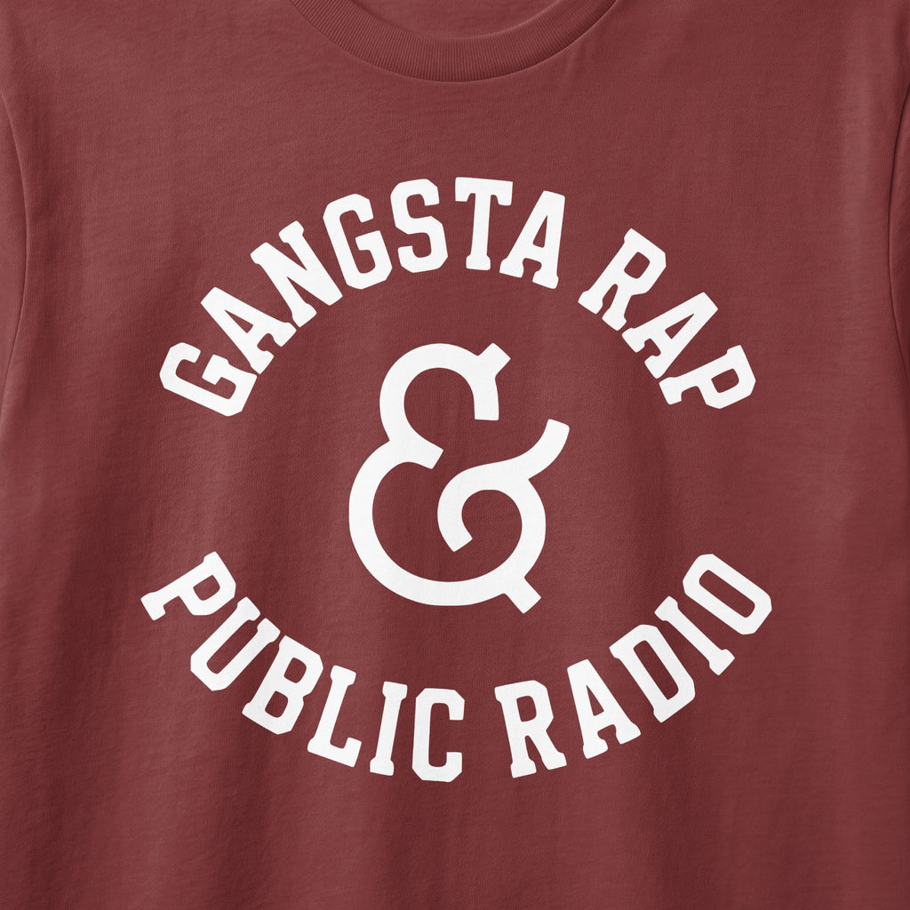 Brown t-shirt with white text "Gangsta Rap & Public Radio" in arched font.