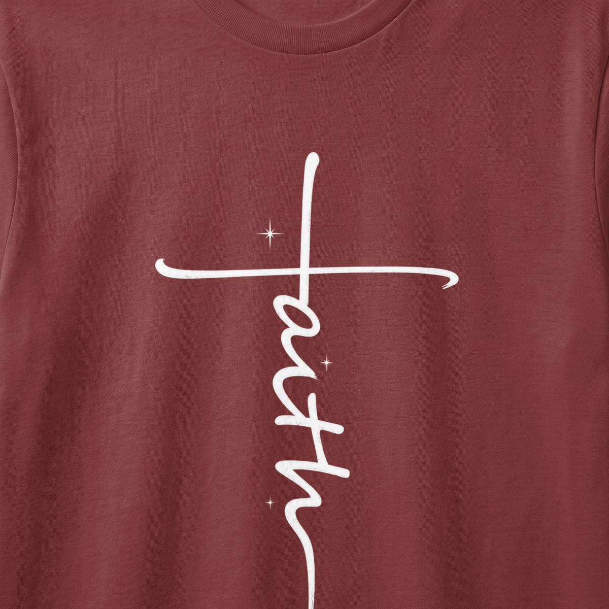 Maroon t-shirt with a white vertical "faith" cross graphic and star accents.