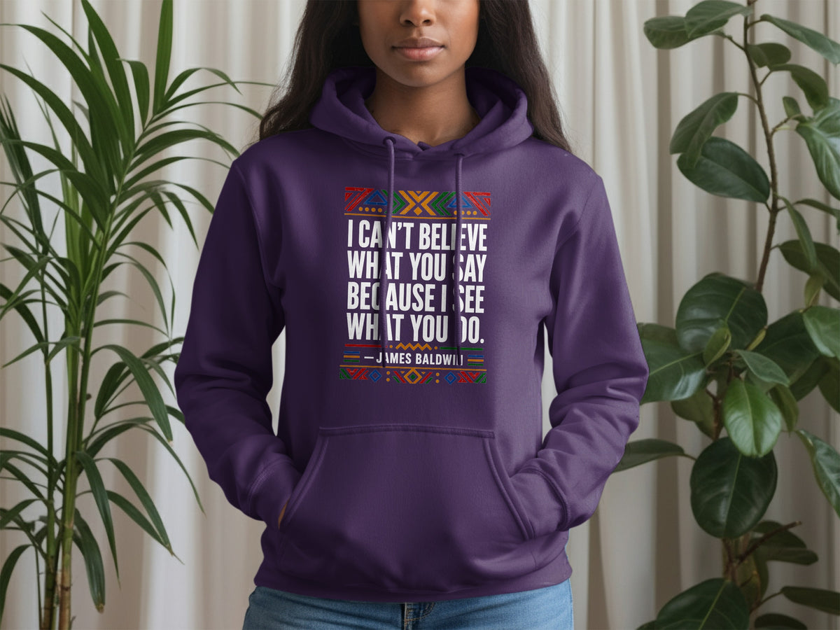Purple hoodie with James Baldwin quote: "I can't believe what you say because I see what you do."