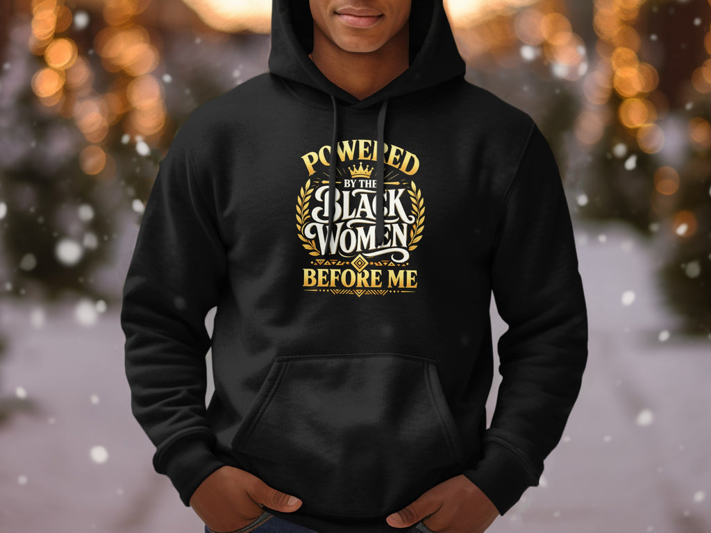 Black hoodie with gold text "Powered by the Black Women Before Me"
