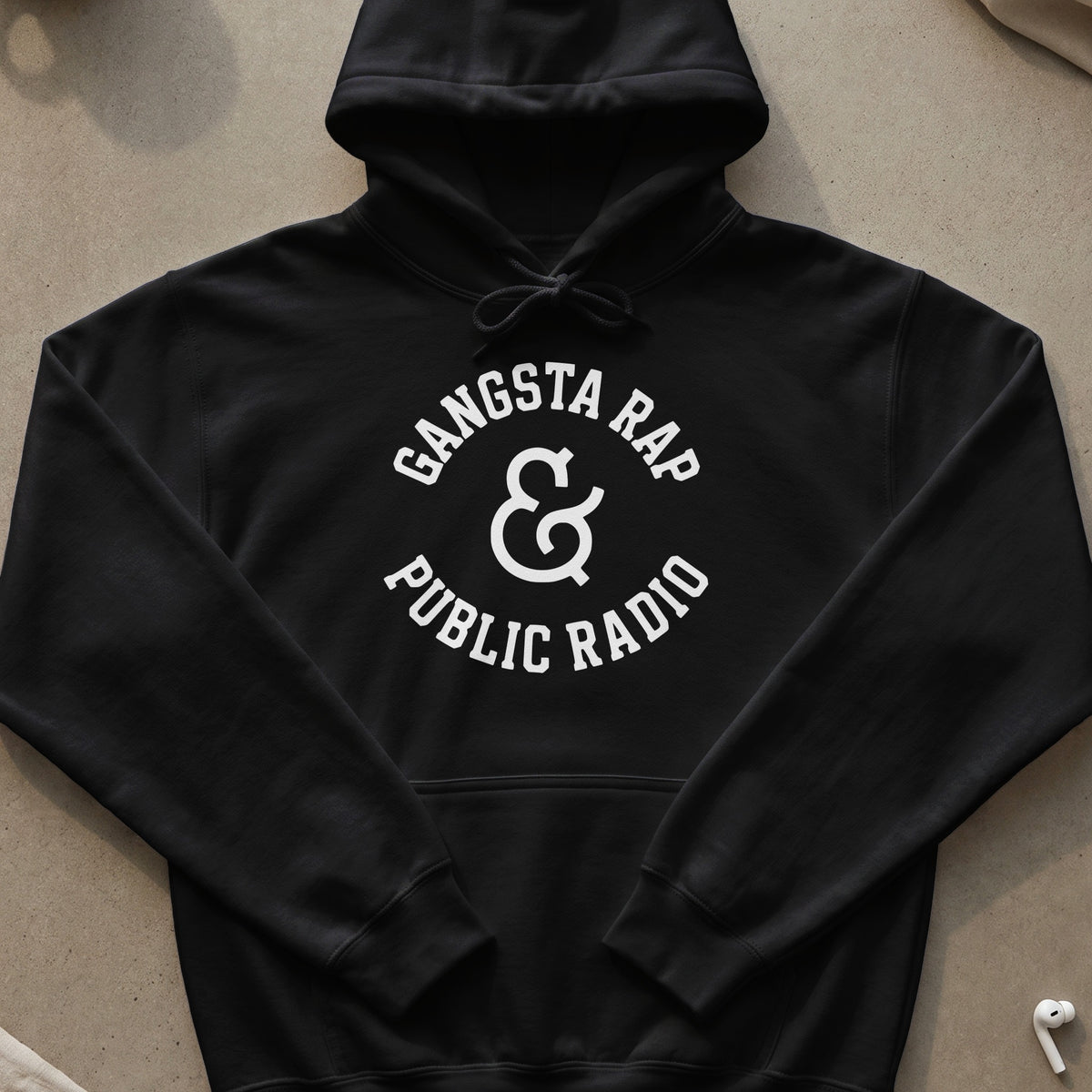 Black hoodie with white text "Gangsta Rap & Public Radio" in a circular design.
