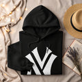 Black hoodie with white NY logo, straw hat, book, and fairy lights.