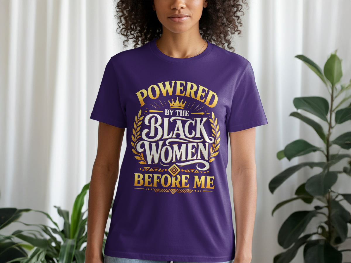 Purple t-shirt with gold text: "POWERED BY THE BLACK WOMEN BEFORE ME"