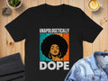 Black t-shirt with graphic of woman with afro, text "UNAPOLOGETICALLY DOPE".