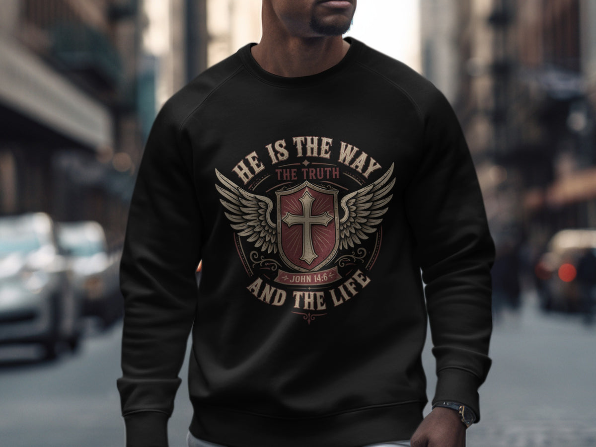 Black sweatshirt with a shield, wings, cross, and text "HE IS THE WAY THE TRUTH AND THE LIFE JOHN 14:6".