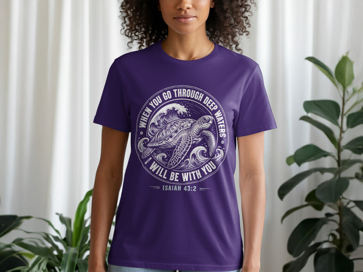 Purple t-shirt with a white graphic of a sea turtle in waves and text from Isaiah 43:2.