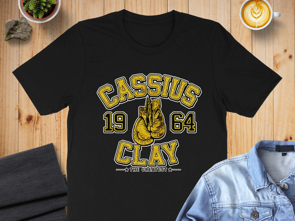 Black t-shirt with Cassius 1964 Clay The Greatest boxing glove graphic.