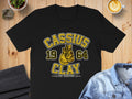Black t-shirt with Cassius 1964 Clay The Greatest boxing glove graphic.