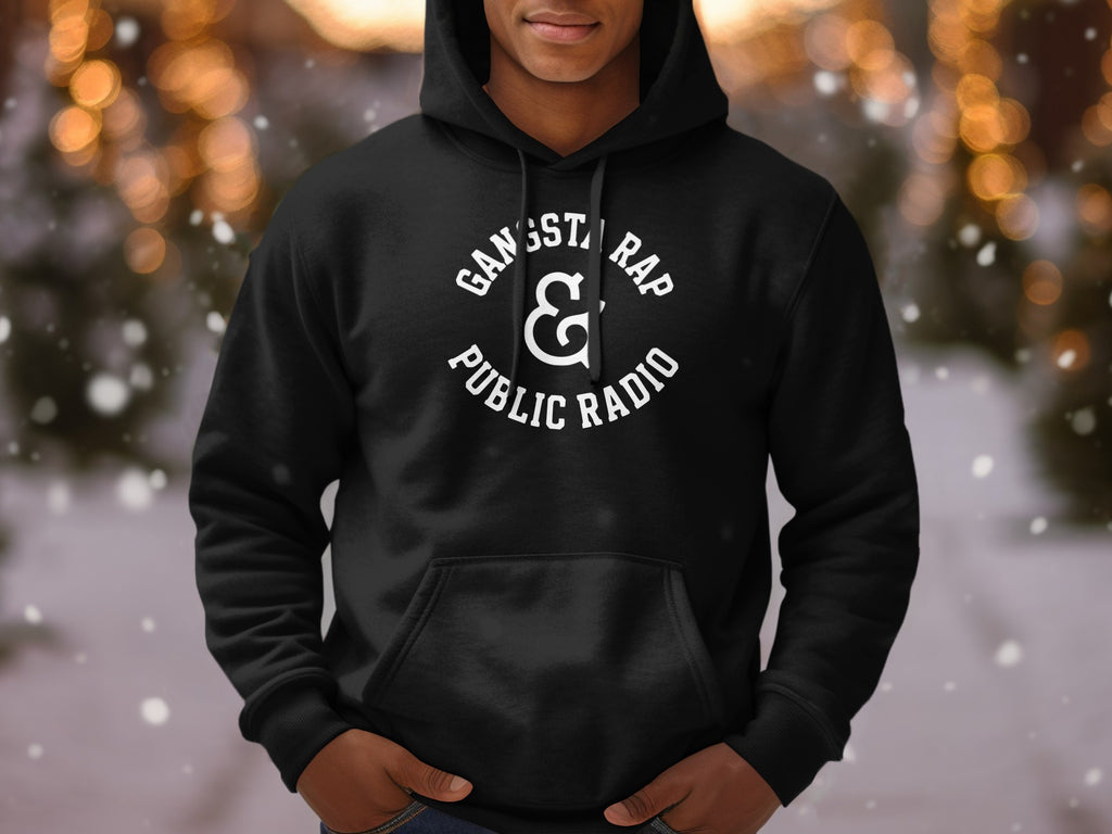 Black hoodie with "Gangsta Rap & Public Radio" text graphic and bokeh background.