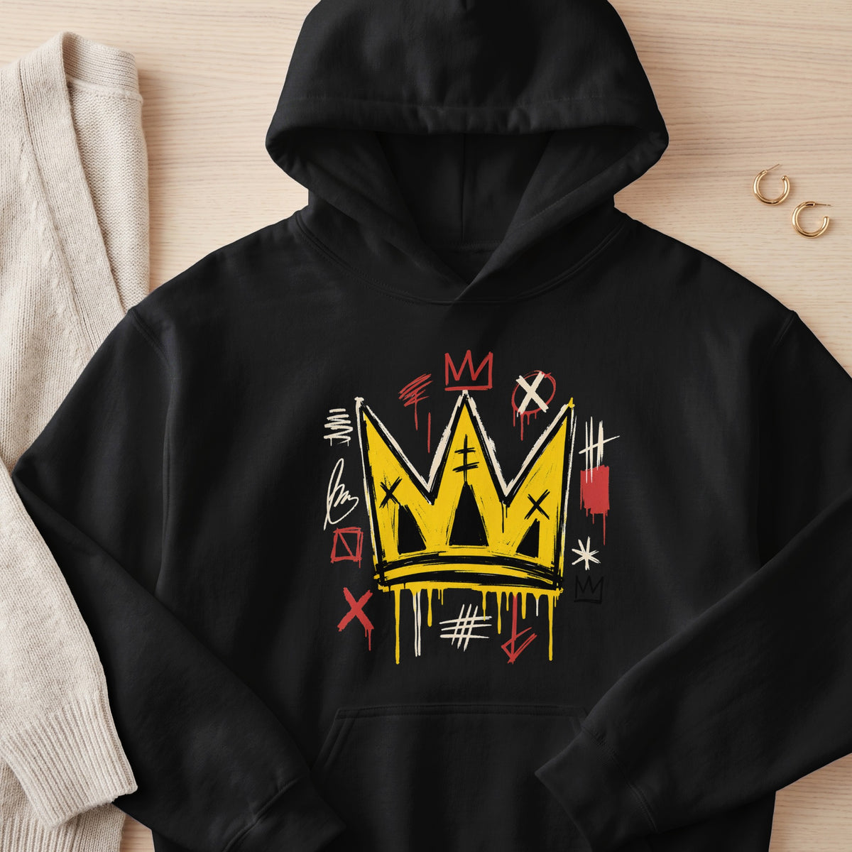 Black hoodie with yellow graffiti crown graphic and assorted markings.