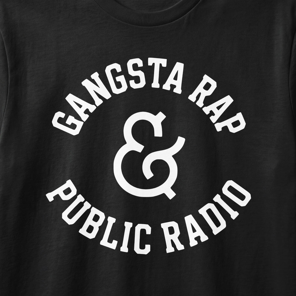 Black t-shirt with white text reading "Gangsta Rap & Public Radio" in a circular design.