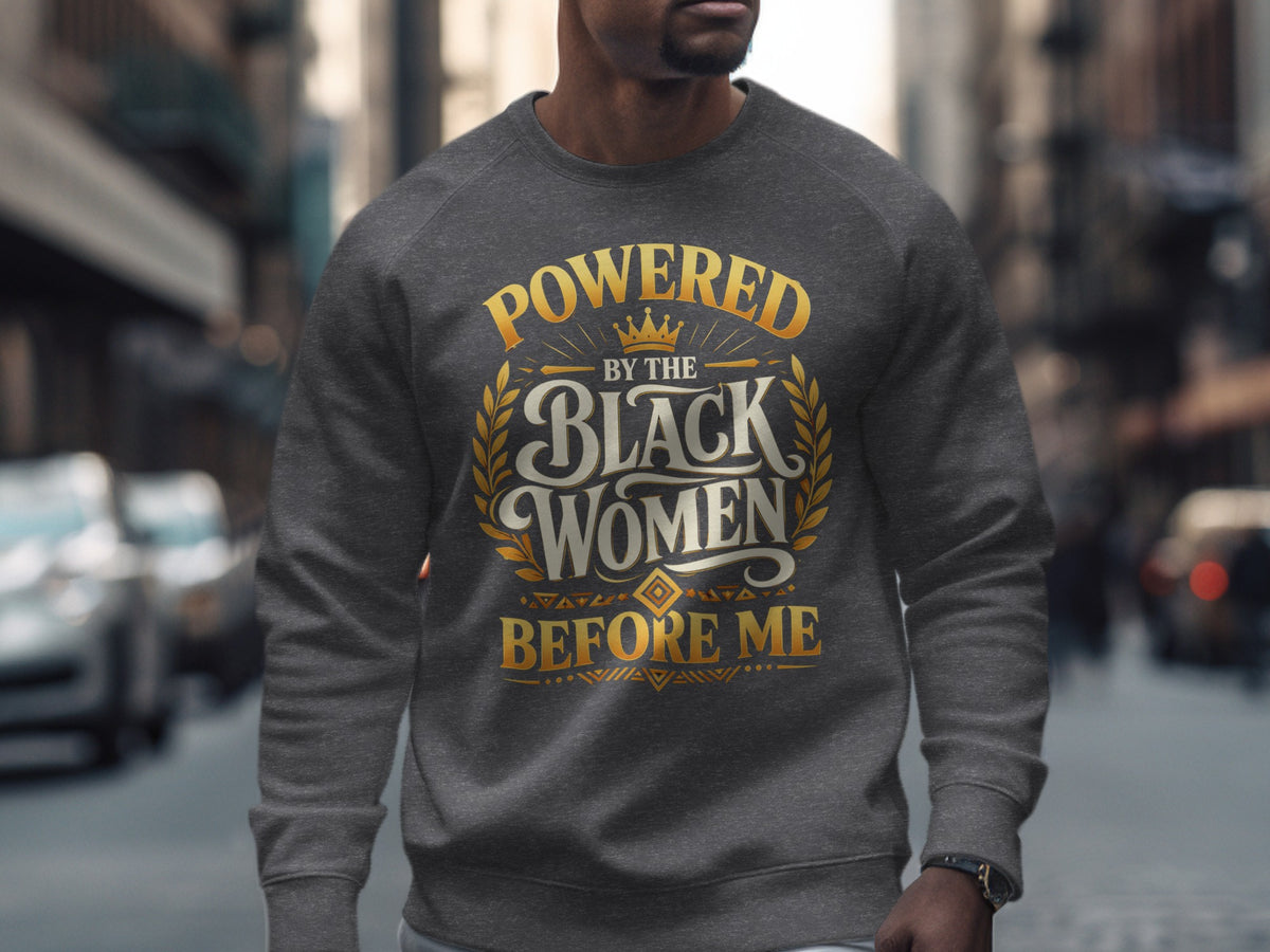 Dark grey sweatshirt with gold text "Powered By The Black Women Before Me".