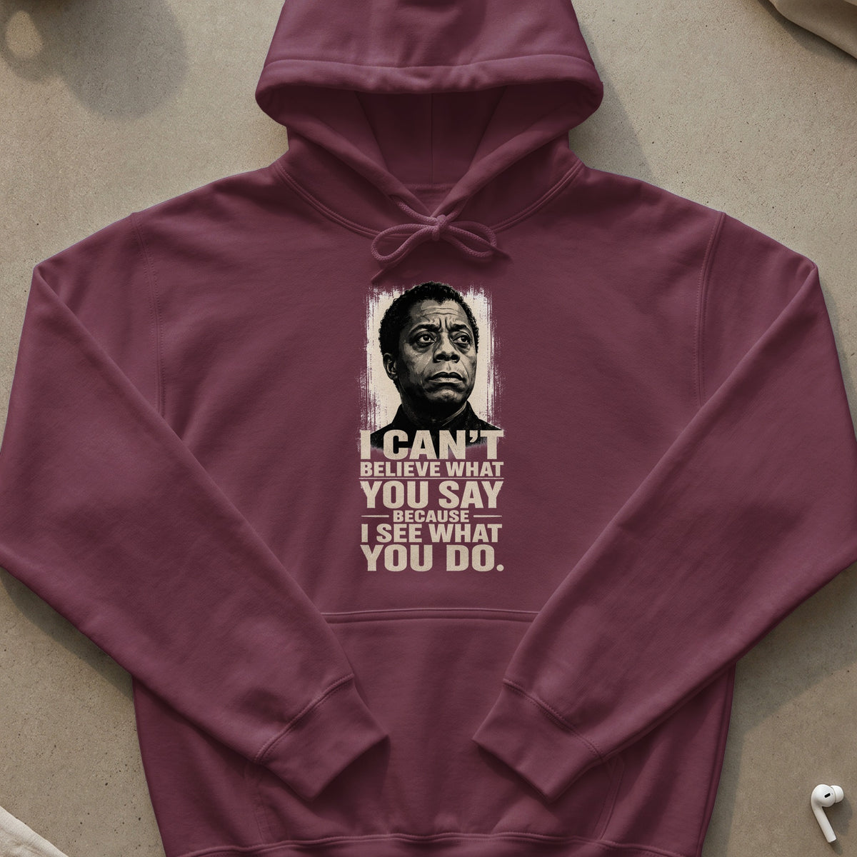 Maroon hoodie with James Baldwin portrait and quote "I can't believe what you say because I see what you do."