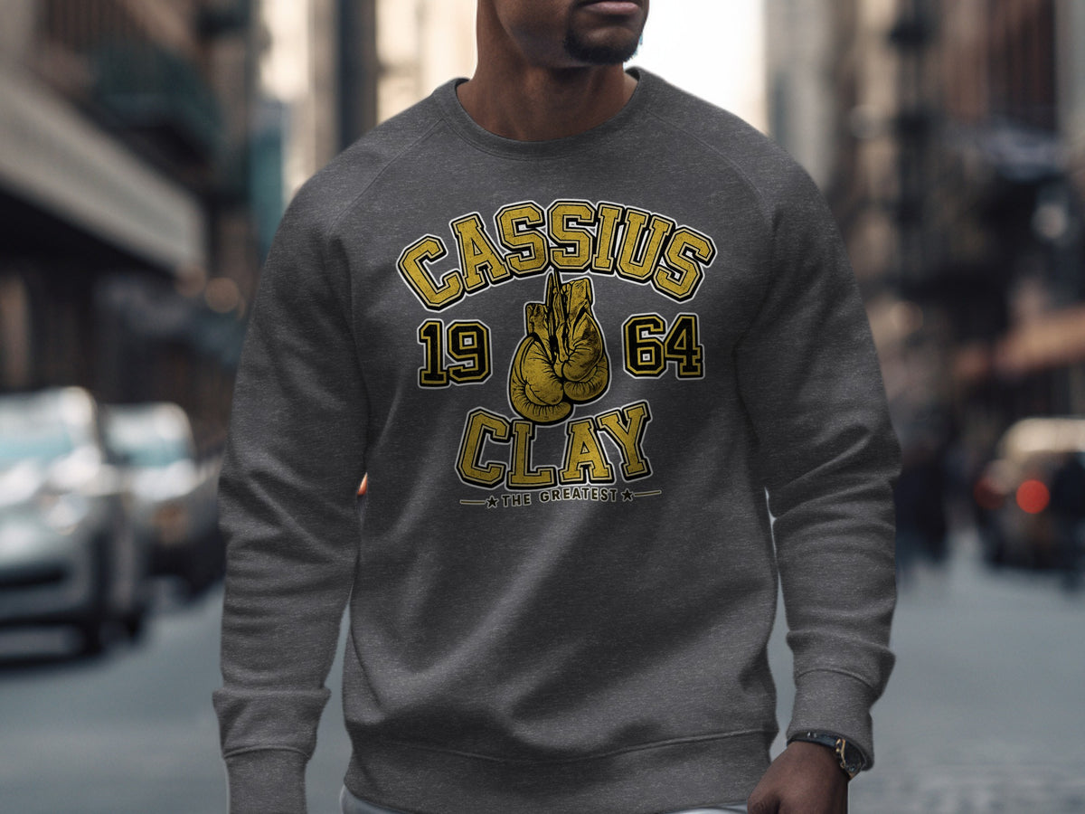 Grey sweatshirt with "Cassius 1964 Clay The Greatest" and boxing gloves graphic.