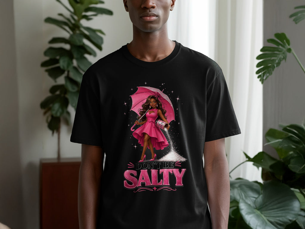 Black t-shirt with cartoon of woman holding umbrella and salt shaker. Text reads "Don't Be Salty".