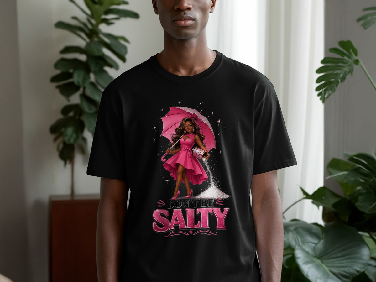 Black t-shirt with cartoon of woman holding umbrella and salt shaker. Text reads "Don't Be Salty".