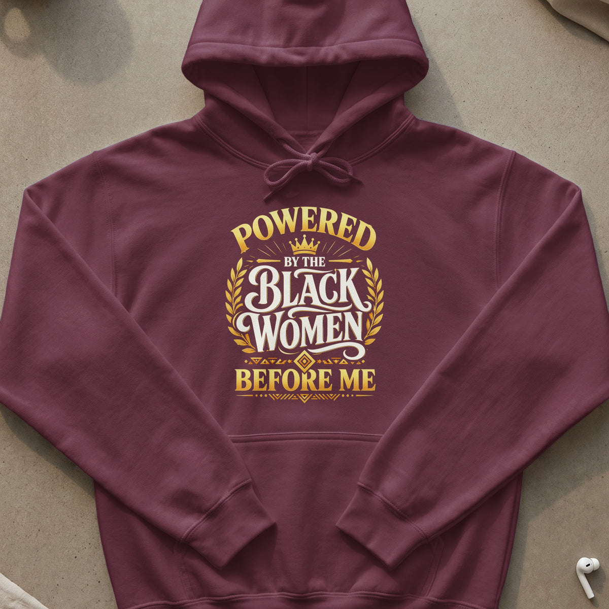 Maroon hoodie with gold text "Powered by the Black Women Before Me."