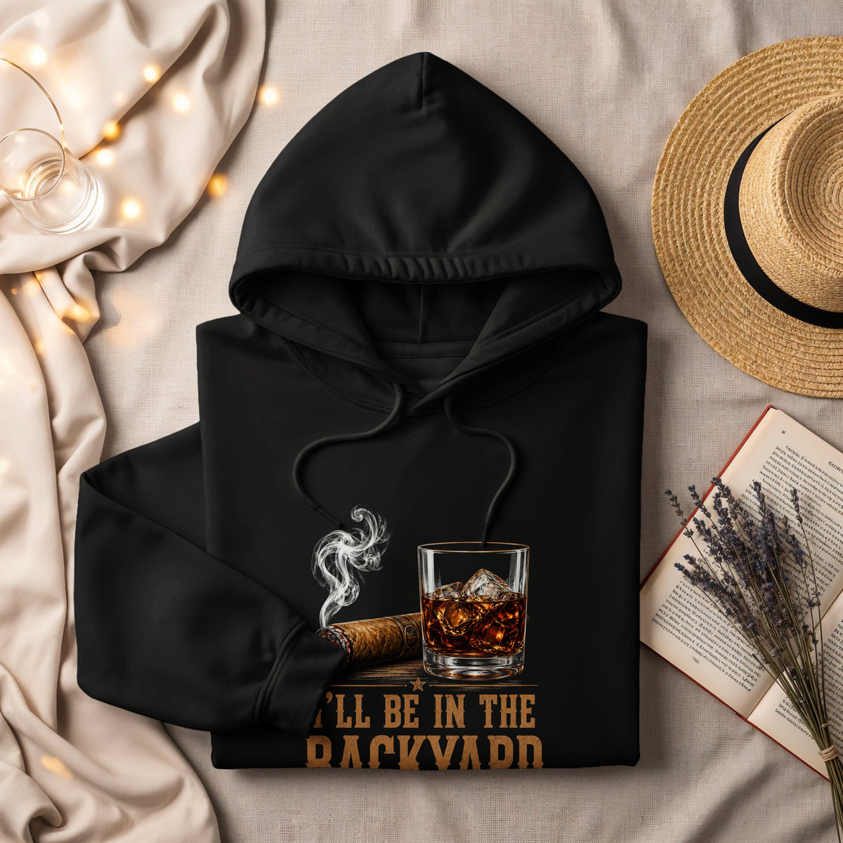 Black hoodie with cigar, whiskey, and text that reads "I'LL BE IN THE BACKYARD".