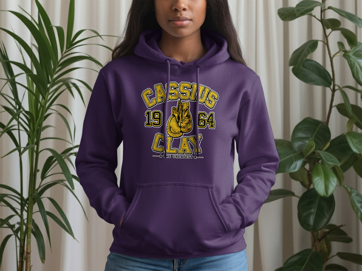 Purple hoodie with "Cassius Clay 1964 The Greatest" and boxing gloves graphic.