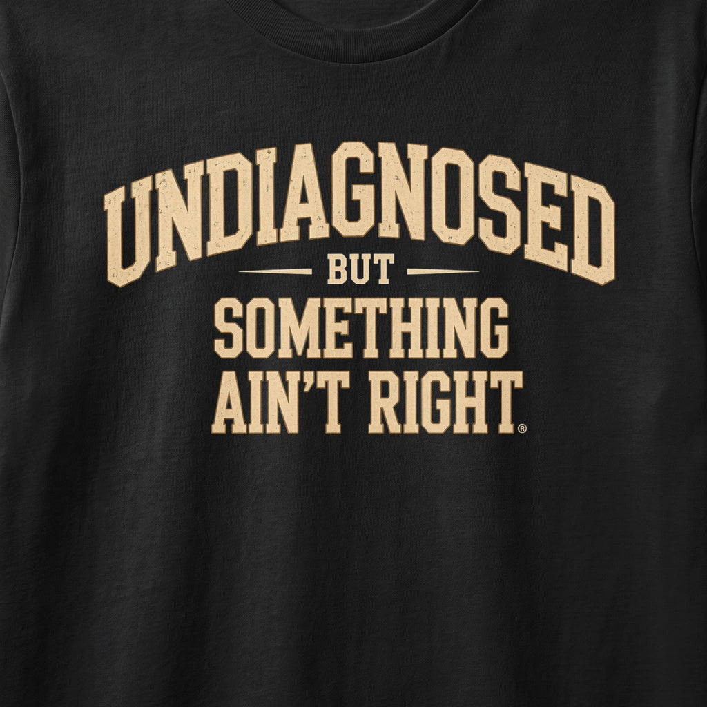 Black shirt with tan text: UNDIAGNOSED BUT SOMETHING AIN'T RIGHT.