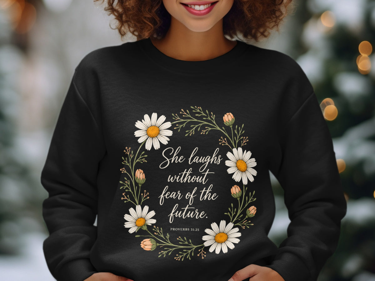 Black sweatshirt with floral wreath and quote "She laughs without fear of the future."