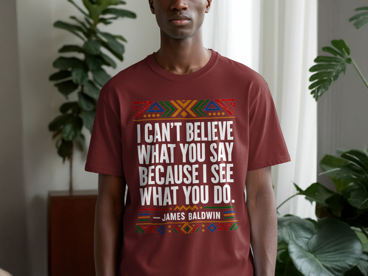 Maroon t-shirt with white text "I CAN'T BELIEVE WHAT YOU SAY BECAUSE I SEE WHAT YOU DO. - JAMES BALDWIN".