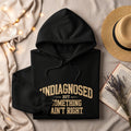 Black hoodie with text "undiagnosed but something ain't right."