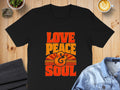 Black t-shirt with "LOVE PEACE & SOUL" text in retro orange and yellow font.