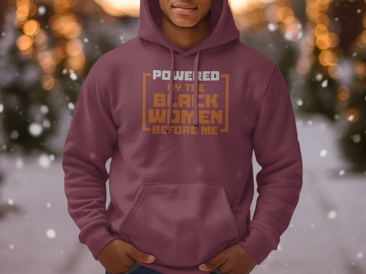 Maroon hoodie with text "POWERED BY THE BLACK WOMEN BEFORE ME" in orange and white.