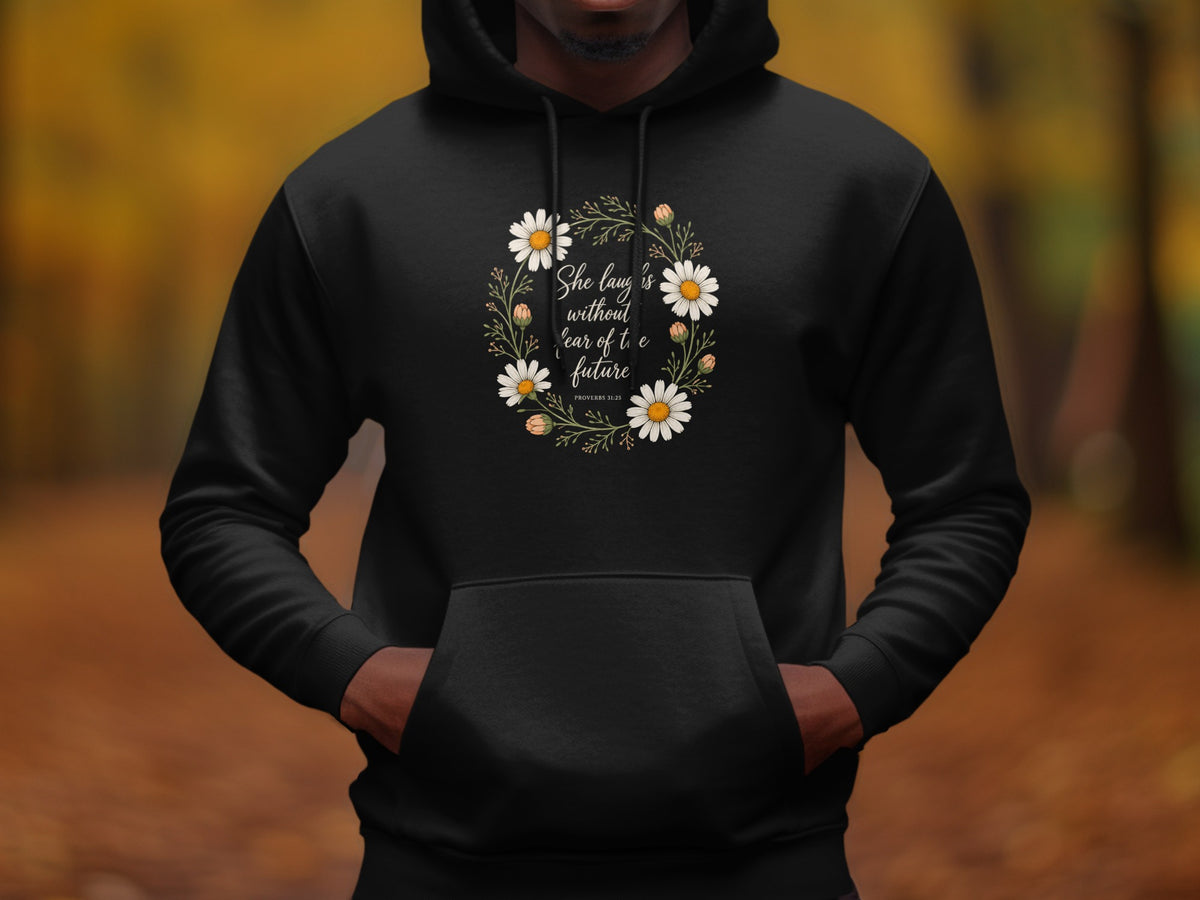 Black hoodie with floral wreath and "She laughs without fear of the future" text.