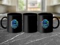 Three black mugs displayed on a dark marbled surface, each featuring a Seattle-themed eagle logo.