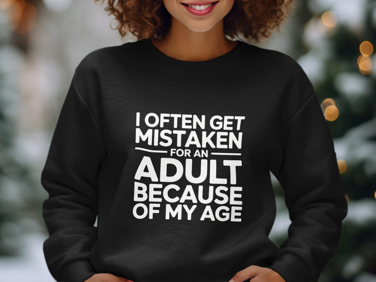 Black crewneck sweatshirt with white text that reads "I OFTEN GET MISTAKEN FOR AN ADULT BECAUSE OF MY AGE".