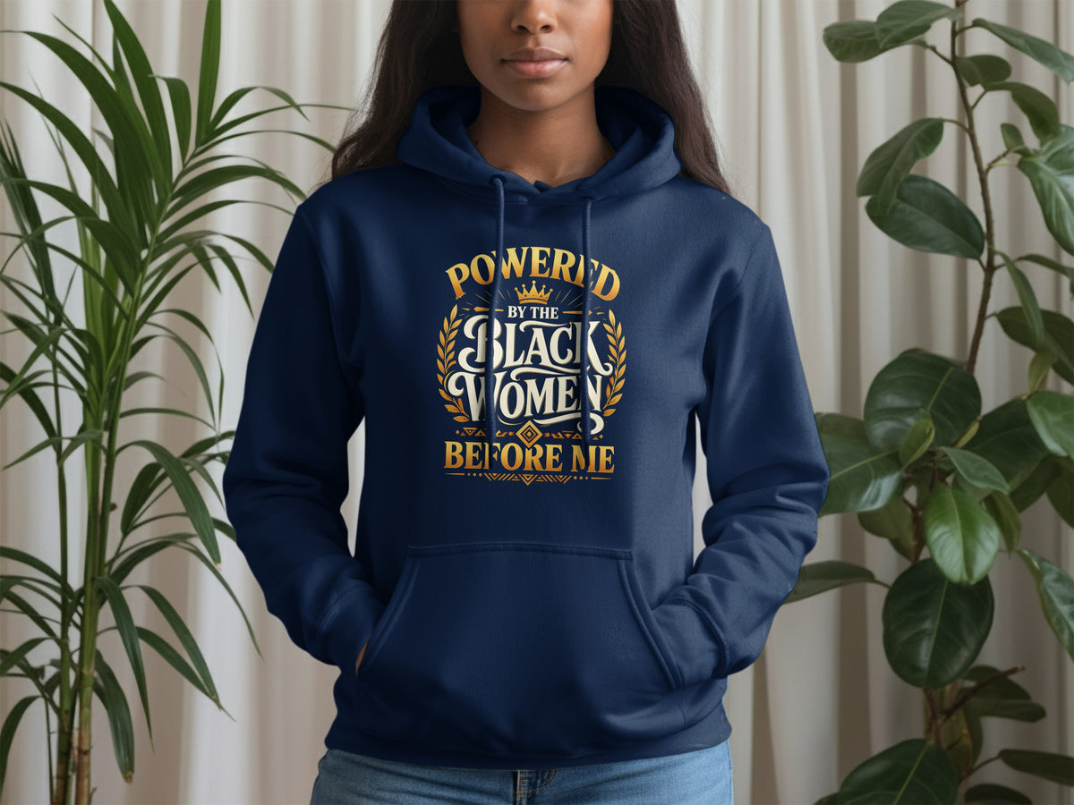 Navy blue hoodie with gold text "Powered by the Black Women Before Me".