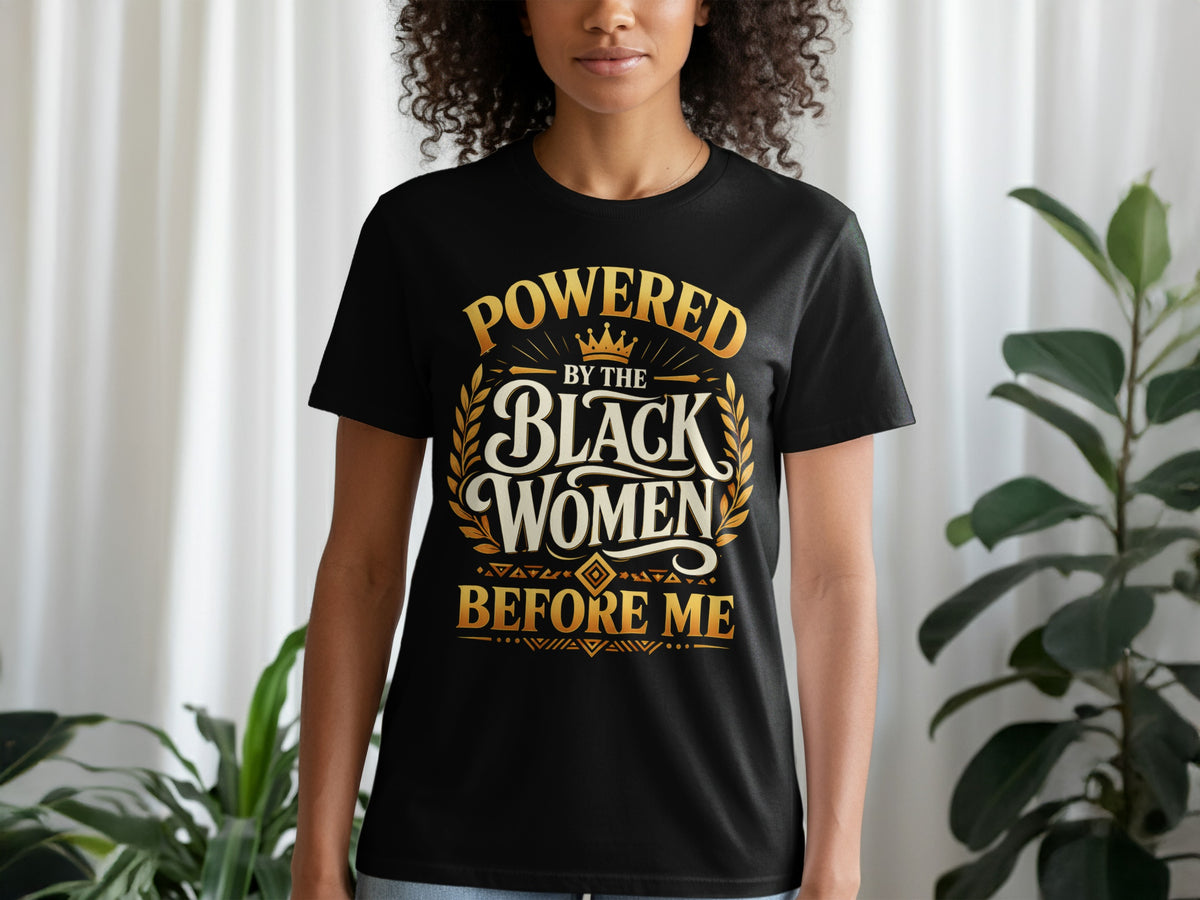 Black t-shirt with gold text: "POWERED BY THE BLACK WOMEN BEFORE ME".