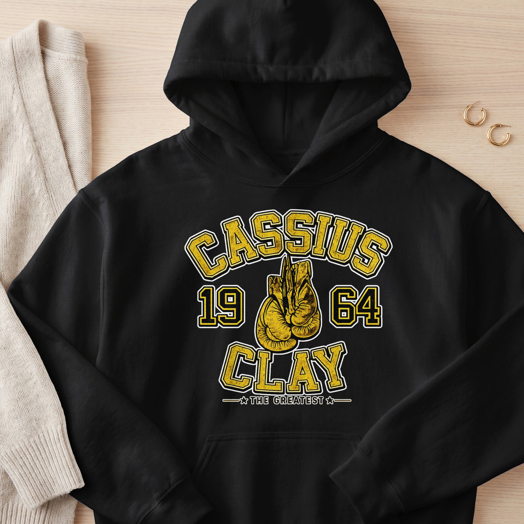 Black hoodie with Cassius Clay 1964 and boxing gloves graphic.