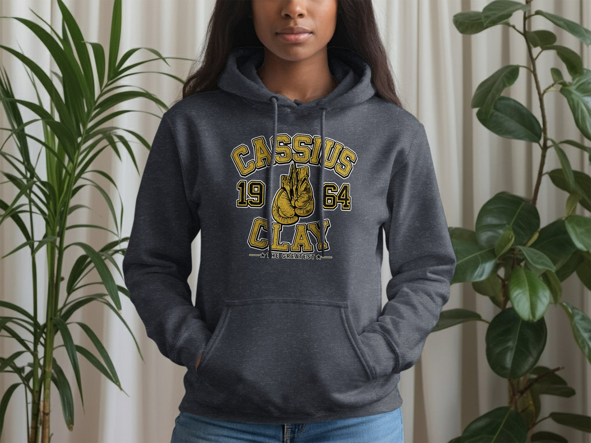 Dark grey hoodie with "Cassius Clay 1964 The Greatest" text and boxing gloves.