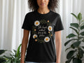 Black t-shirt with daisies and text "She laughs without fear of the future. PROVERBS 31:25".