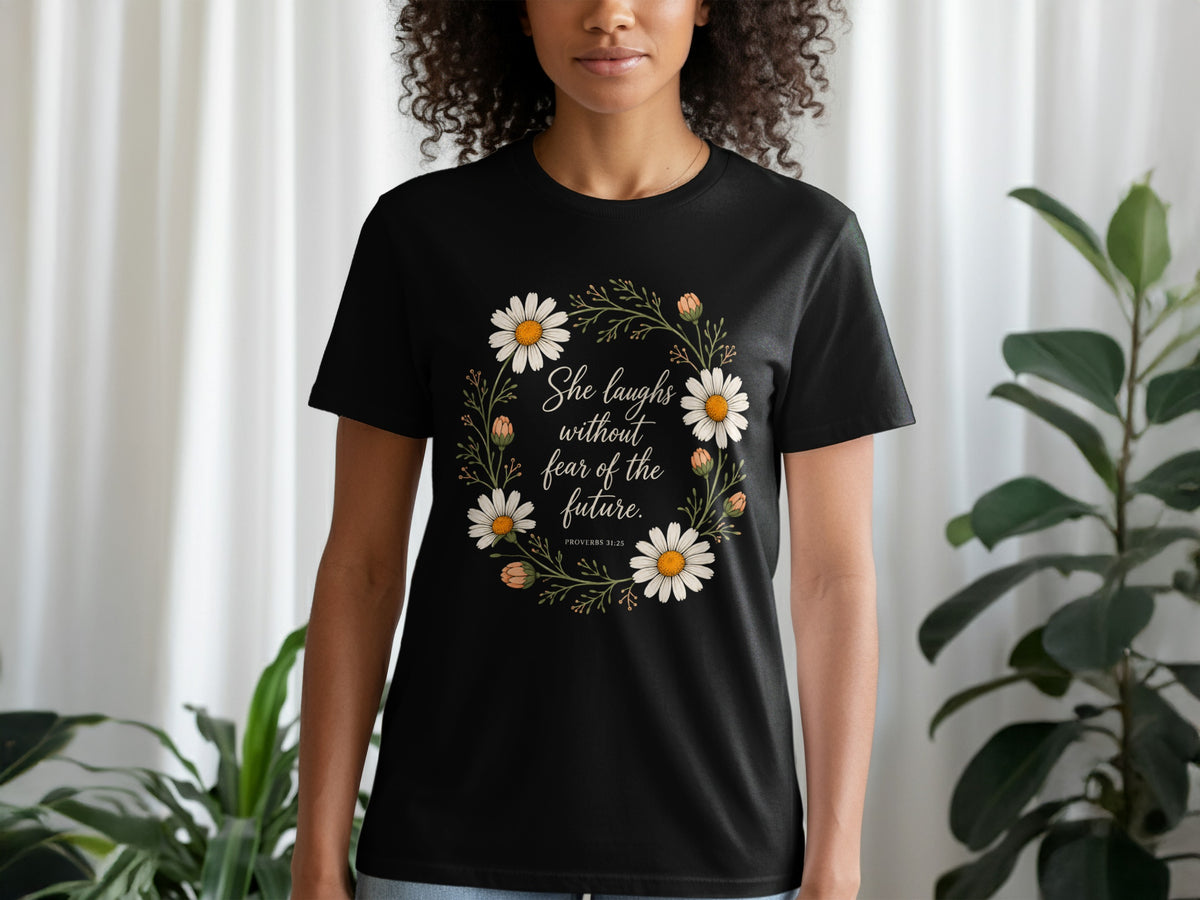 Black t-shirt with daisies and text "She laughs without fear of the future. PROVERBS 31:25".