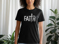 Black t-shirt with white "FAITH" text and a brushstroke cross.