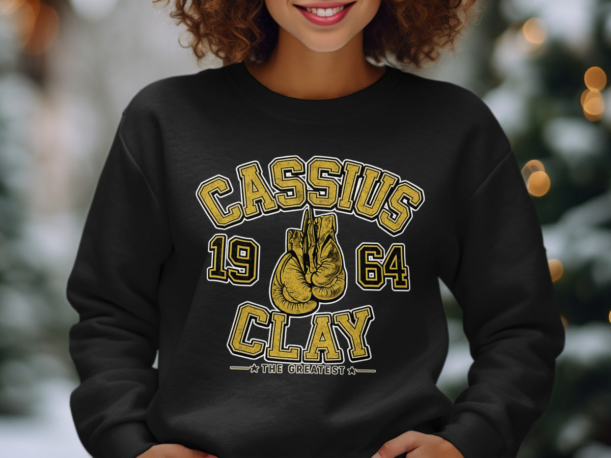 Black sweatshirt with Cassius 1964 Clay "The Greatest" boxing glove graphic.